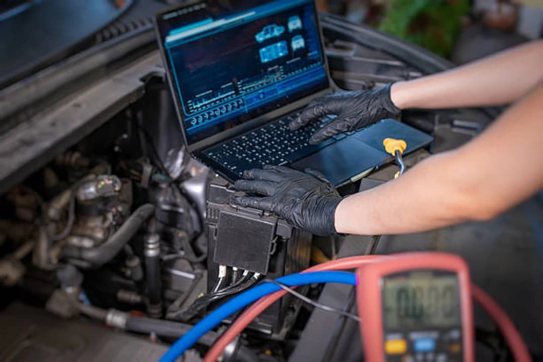 Technician running laptop diagnostics and multimeter testing on an engine at Brilliant Motors Garage, Welling