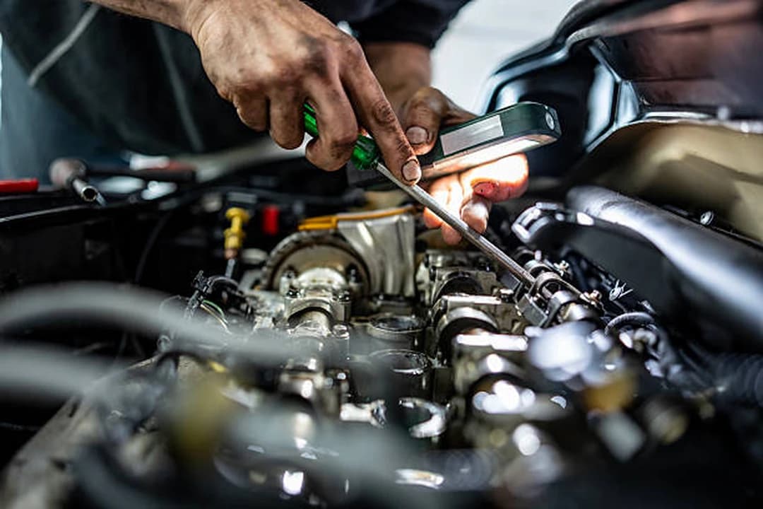 Technician inspecting an open engine by lamplight during an engine rebuild at Brilliant Motors Garage in Welling