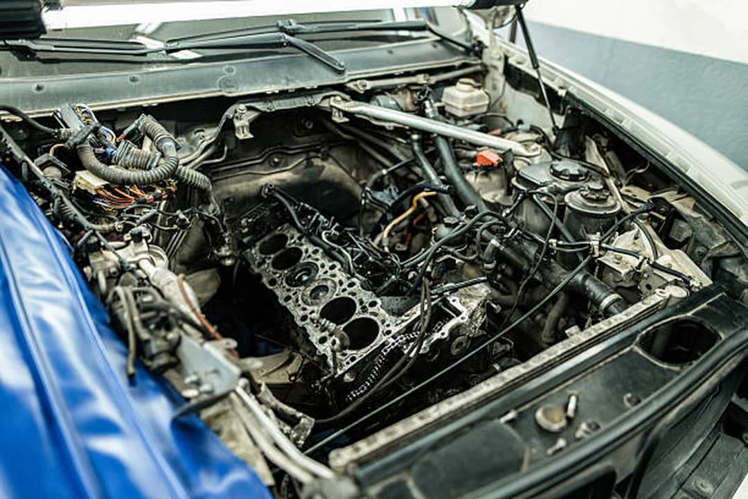 Engine bay with the cylinder head removed and the block exposed during an engine replacement at Brilliant Motors Garage, Welling